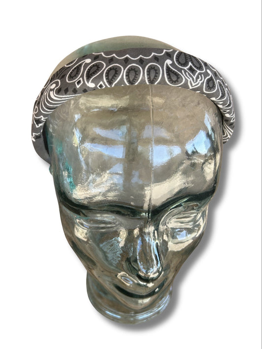 Clear glass head with decorative bandana on a white background