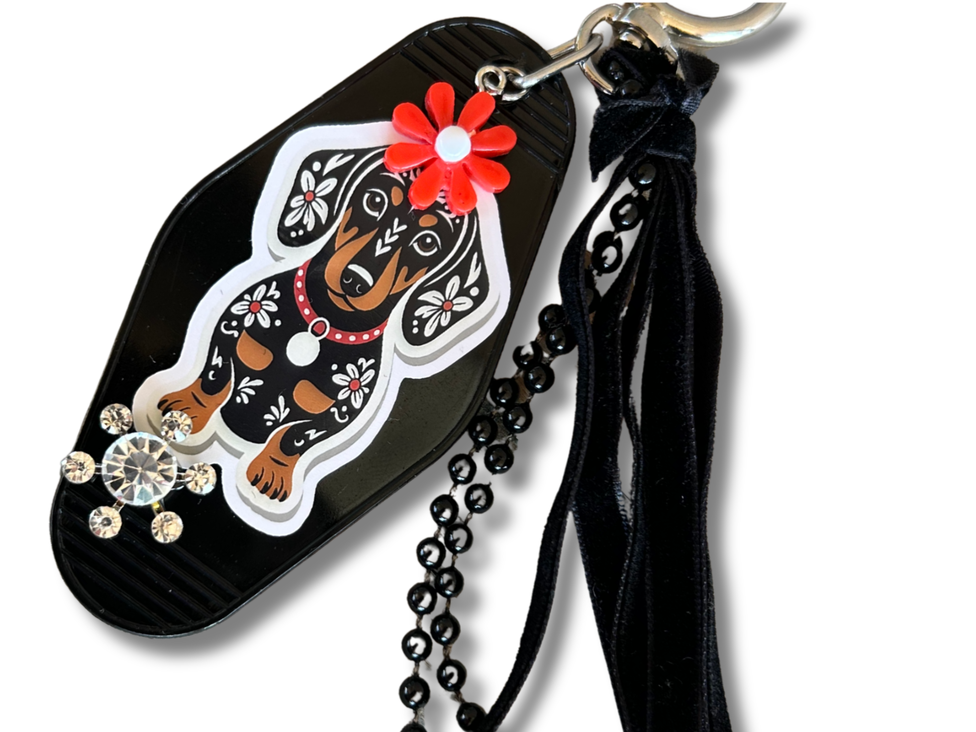 Keychain with dachshund design and decorative elements on a white background