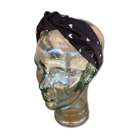 Headband with multi colored hearts through out. The fabric has a black background