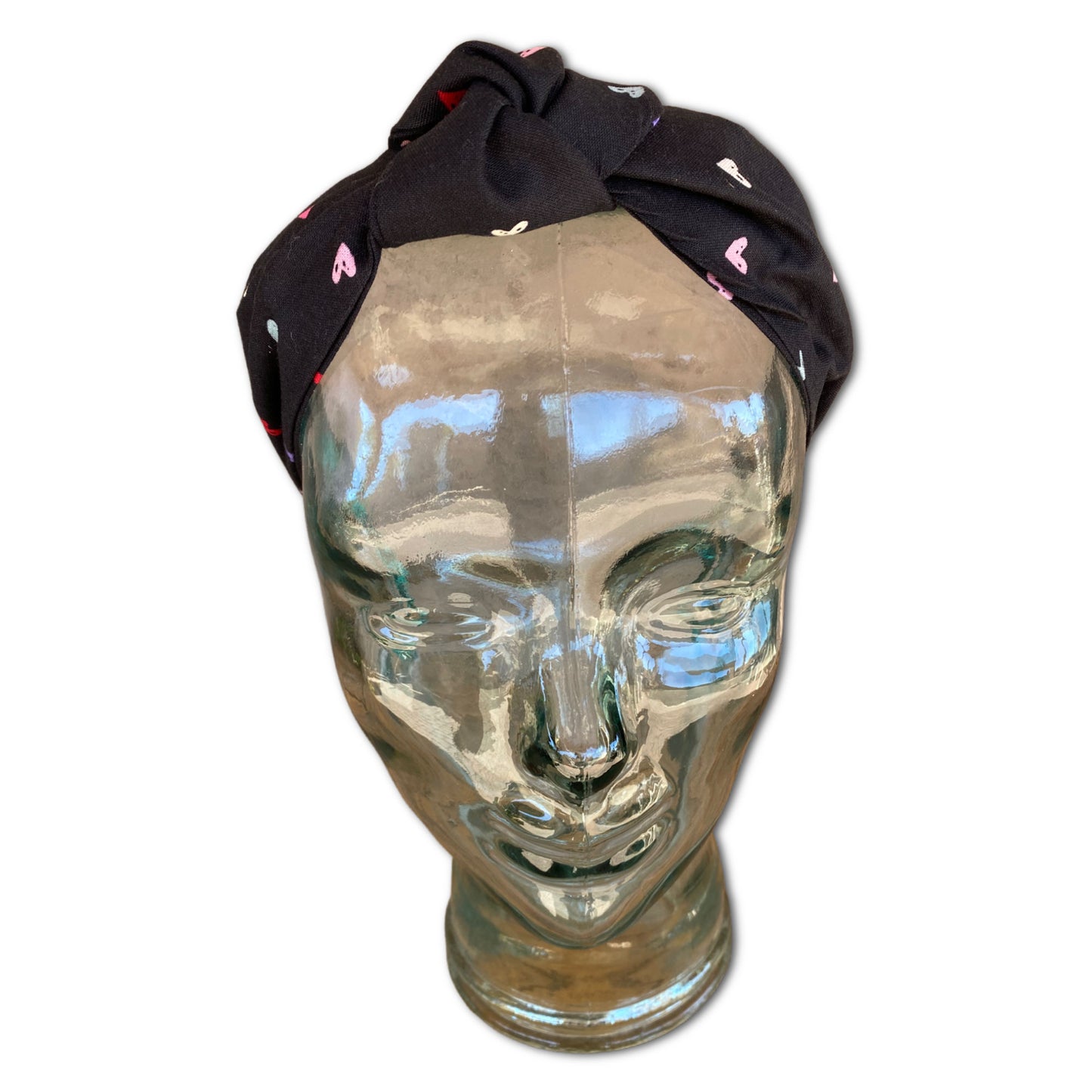 Headband with multi colored hearts through out. The fabric has a black background