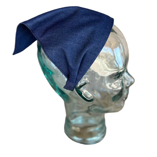 chambray cotton lightweight fabric on a glass mannequin head against a wooden surface.