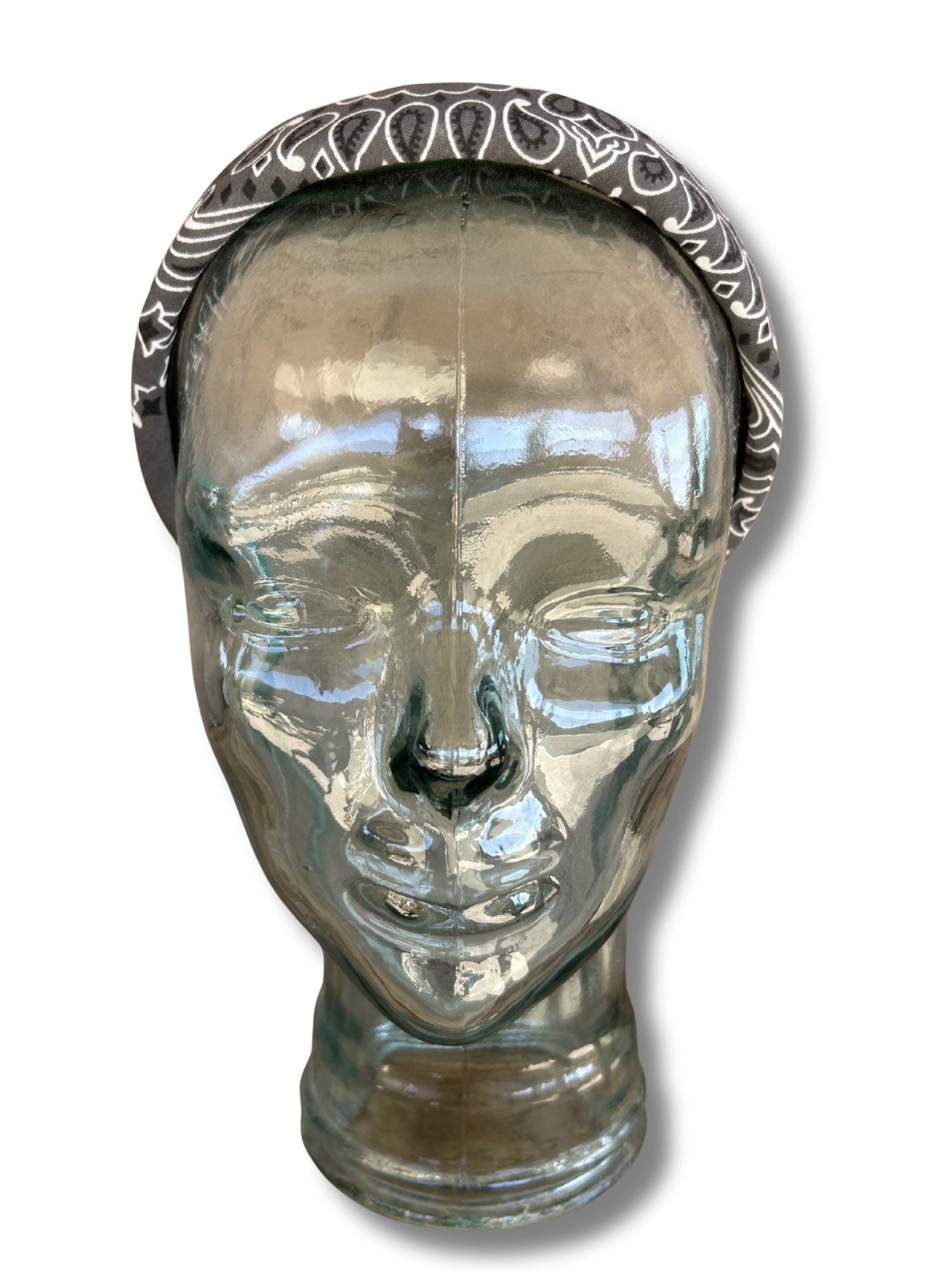 Glass head with decorative silver band on a white background