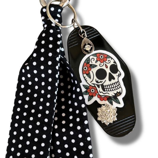 Black polka dot keychain with skull design on a white background