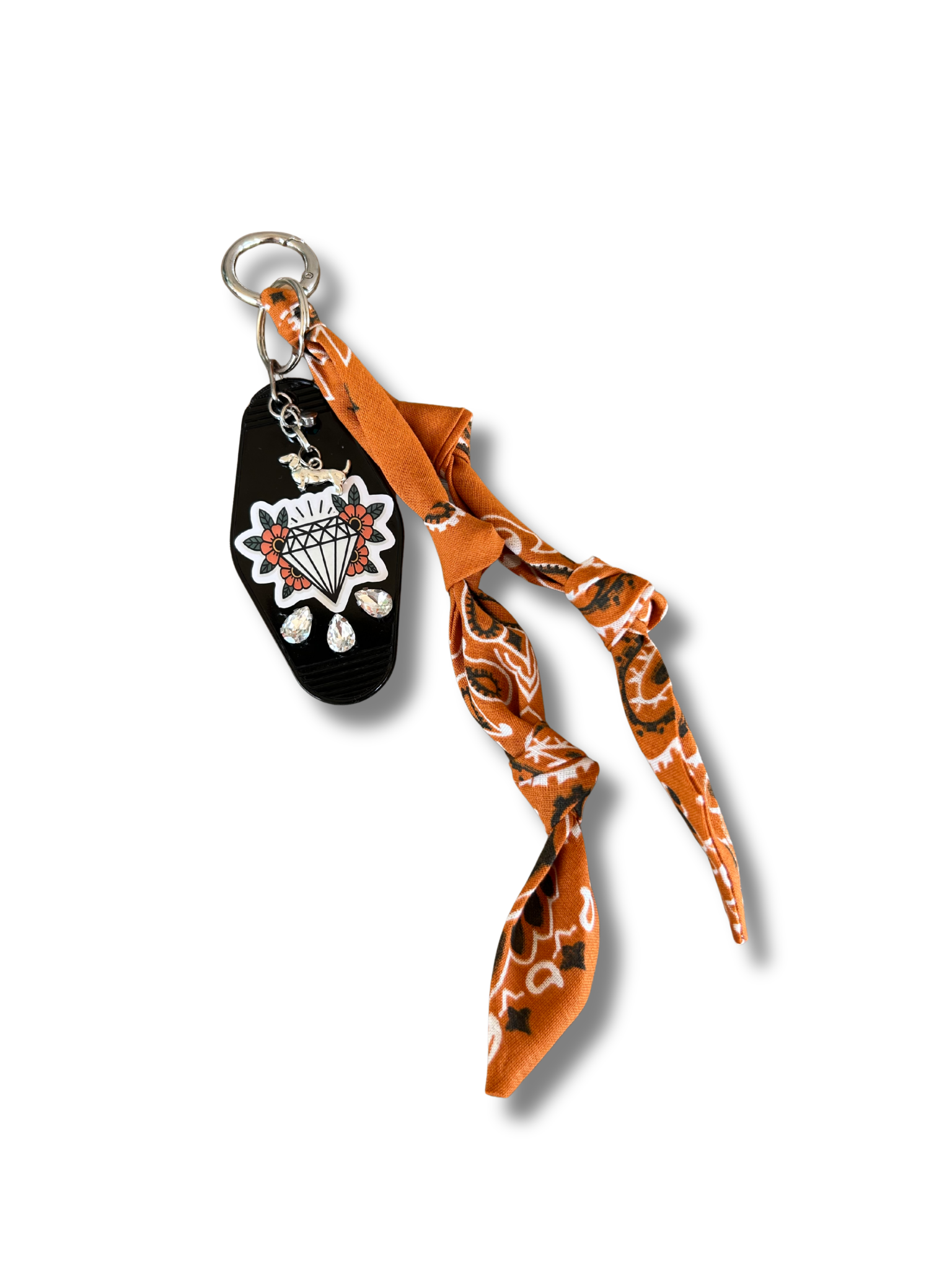 Black and white keychain with orange bandana on a white background