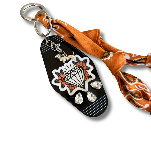hotel key with tattoo diamond images and pumpkin orange bandana bag charm lanyard on a white background