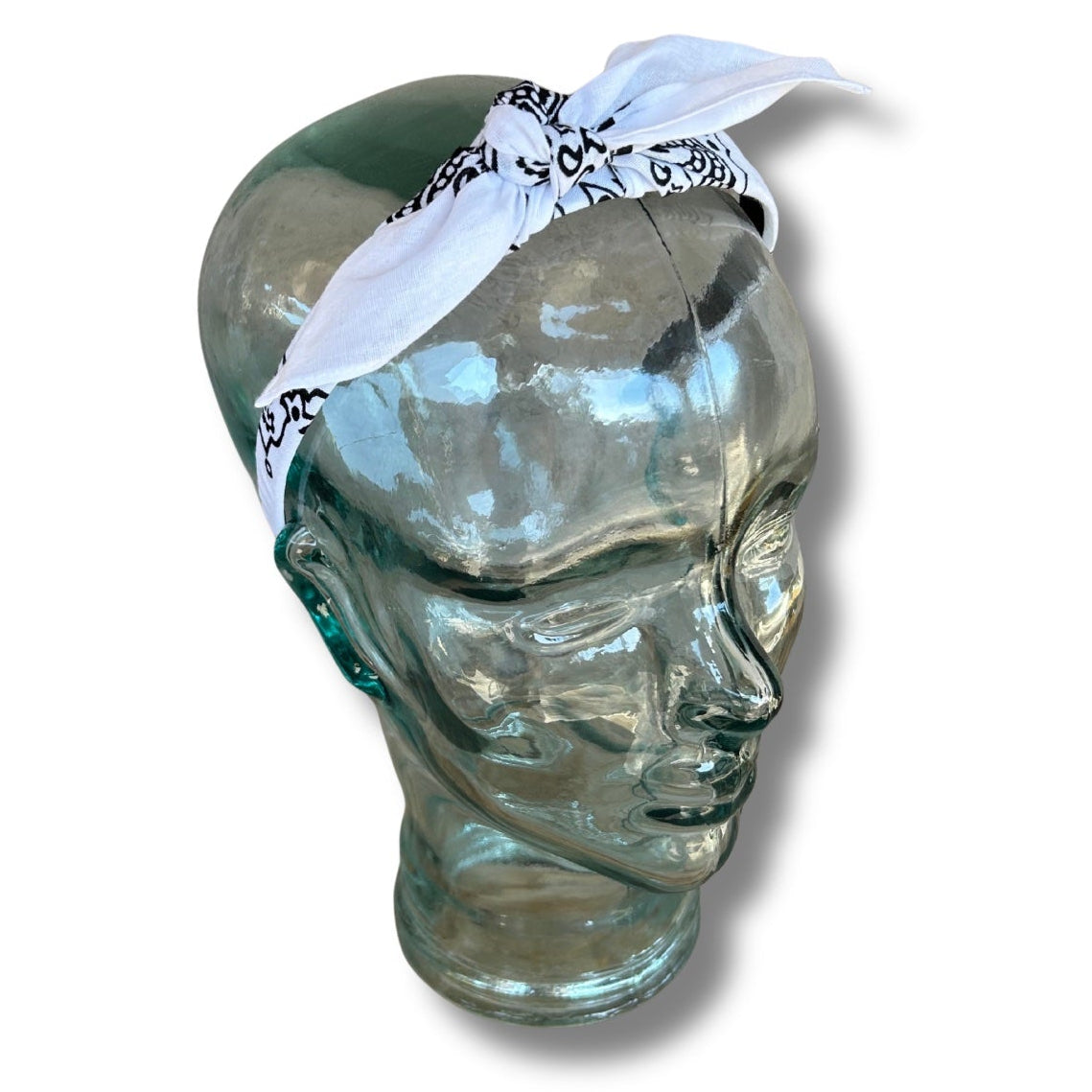 Glass mannequin head with a white bandana on a white background