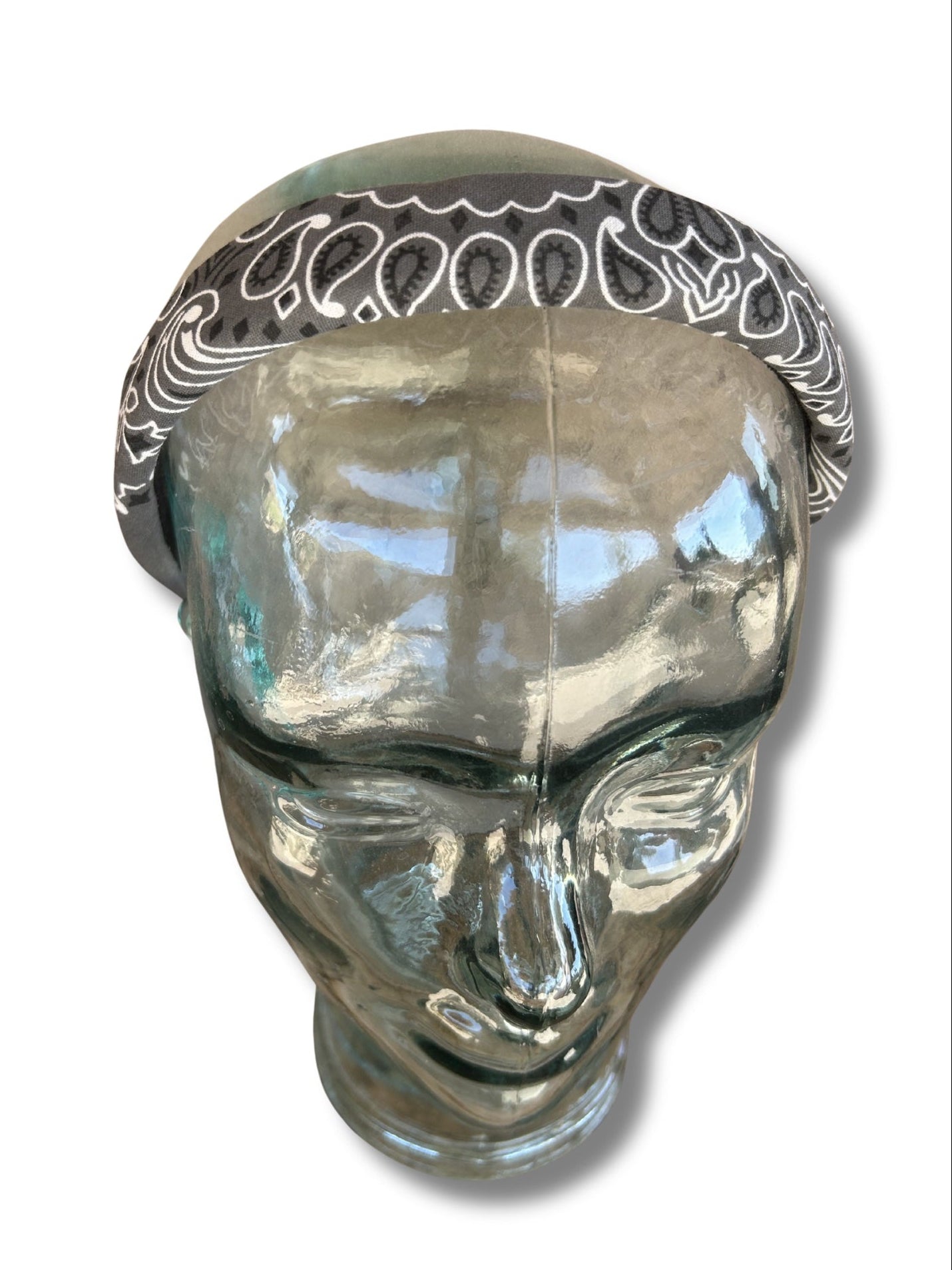Clear glass head with decorative bandana on a white background