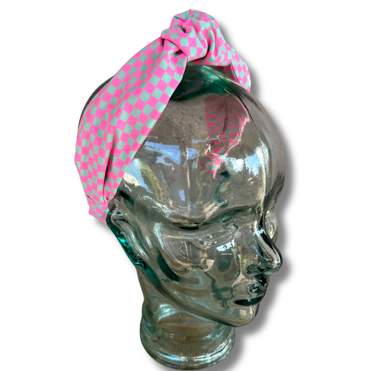Glass head with a pink polka dot headband on a white background