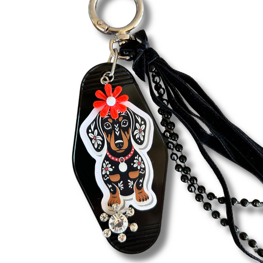 Hotel Keychain, bag charm, featuring a dachshund and decorative elements on a white background.