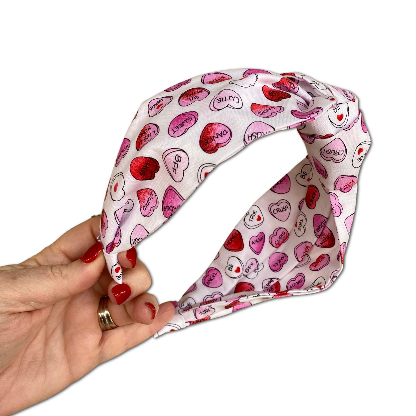 Headband that features pink and red conversation hearts throughout