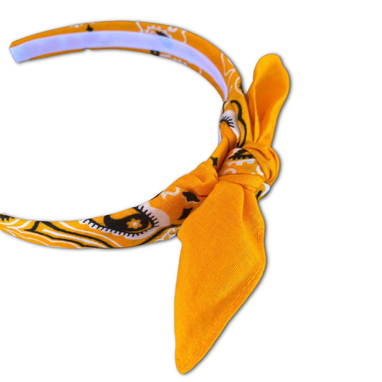 Gold Yellow paisley kerchief bandana is wrapped around a plastic headband and tied in a knot. Hairband is designed to not slip