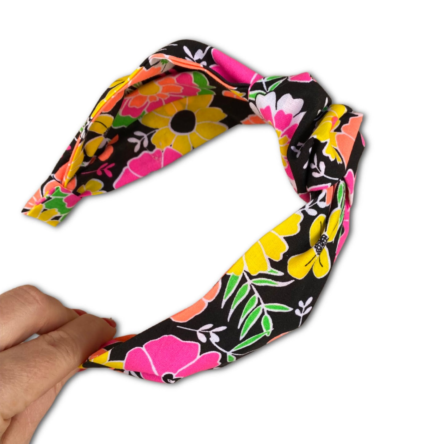 Top knot styled headband with bright neon colored flowers. This hair accessory has a 