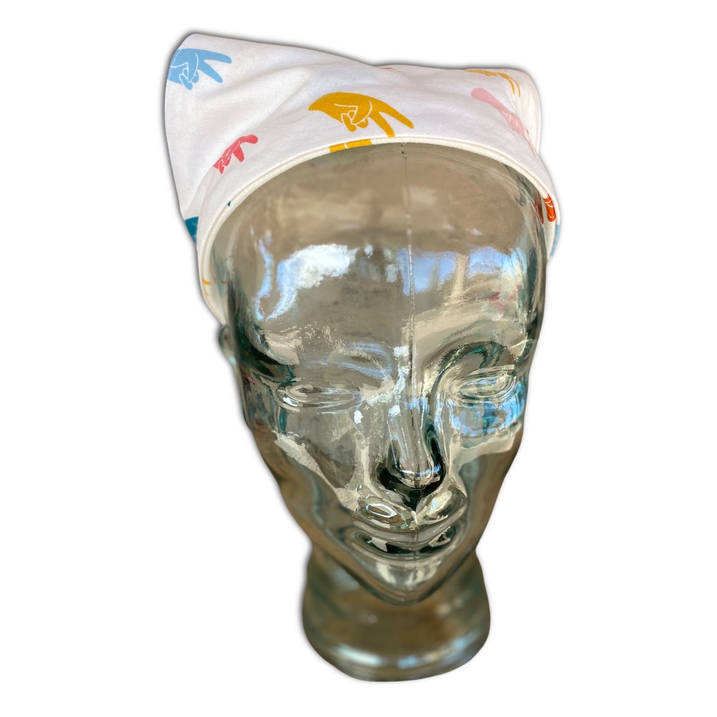 Glass mannequin head wearing a headband head scarf. The head scarf has  hands making the peace sign. 