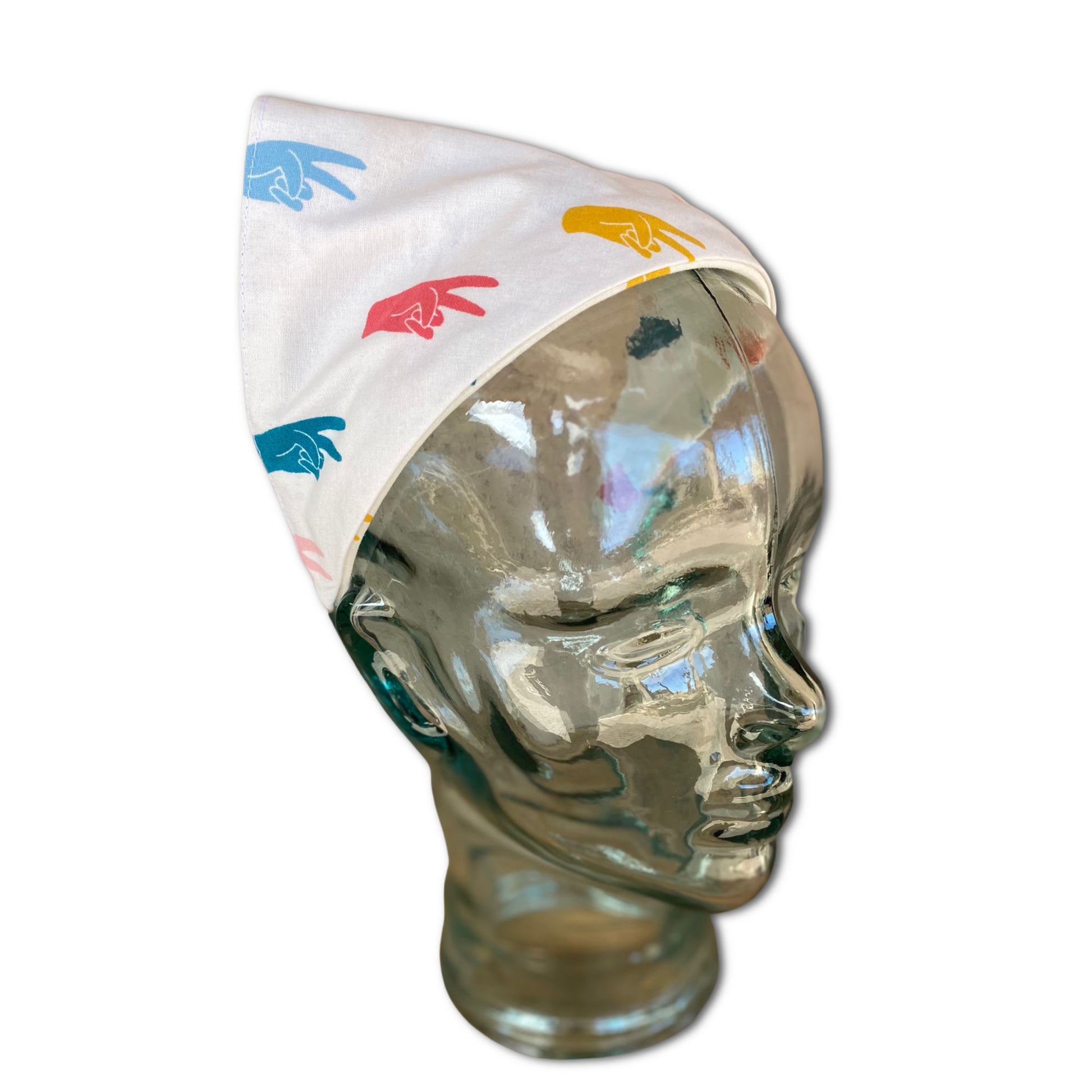 Glass mannequin head wearing a headband head scarf. The head scarf has  hands making the peace sign. 