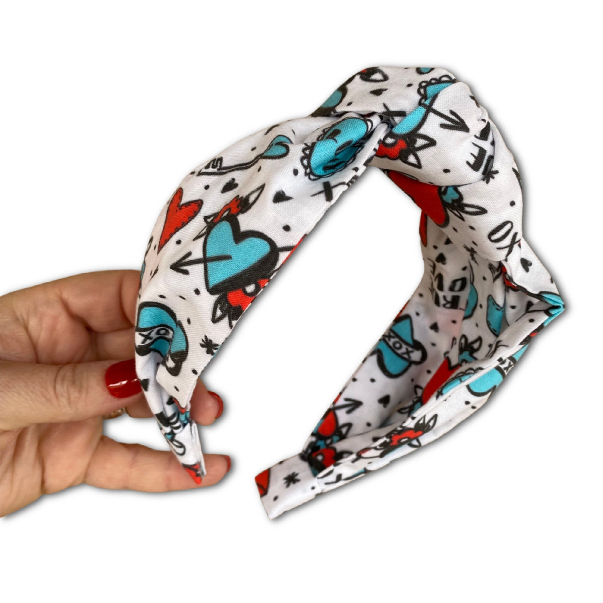 This is a headband with a knot at top. Fabric is a tattoo print with hearts, keys and locks.  Red and Turquoise colors and a white background.