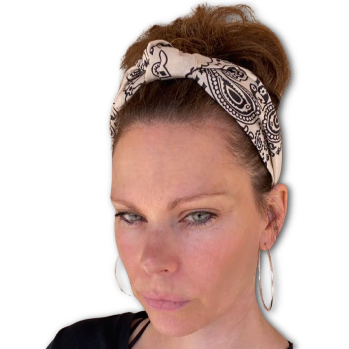 Model wearing beige colored paisley bandana headband that has the knot at the top.