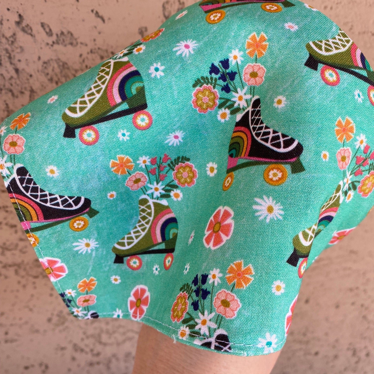 triangle head scarf attached to a headband. features a roller skating print.